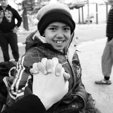 Händchenhalten mit Jungem als Symbolbild für pyschologische Hilfe für Traumatisierte Flüchtlinge